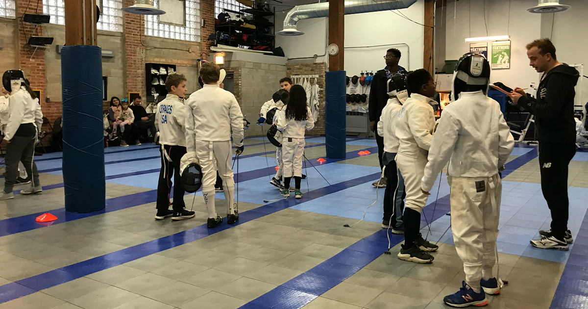 A diverse group of youth fencers training together, representing the Fencing Forward mission of accessible sports mentorship.